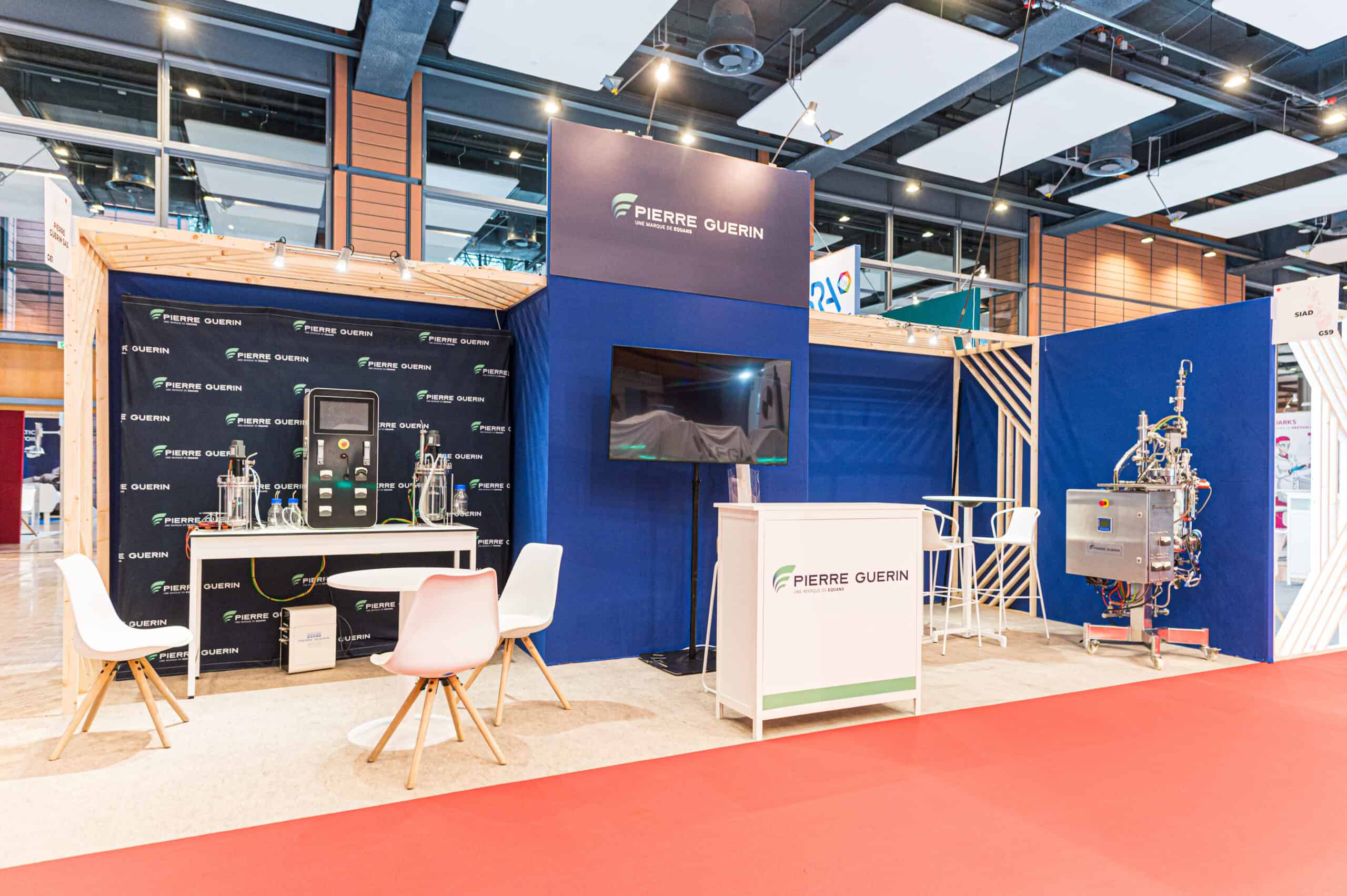 Stand d'exposition lors d'un salon avec mobilier et équipements techniques.