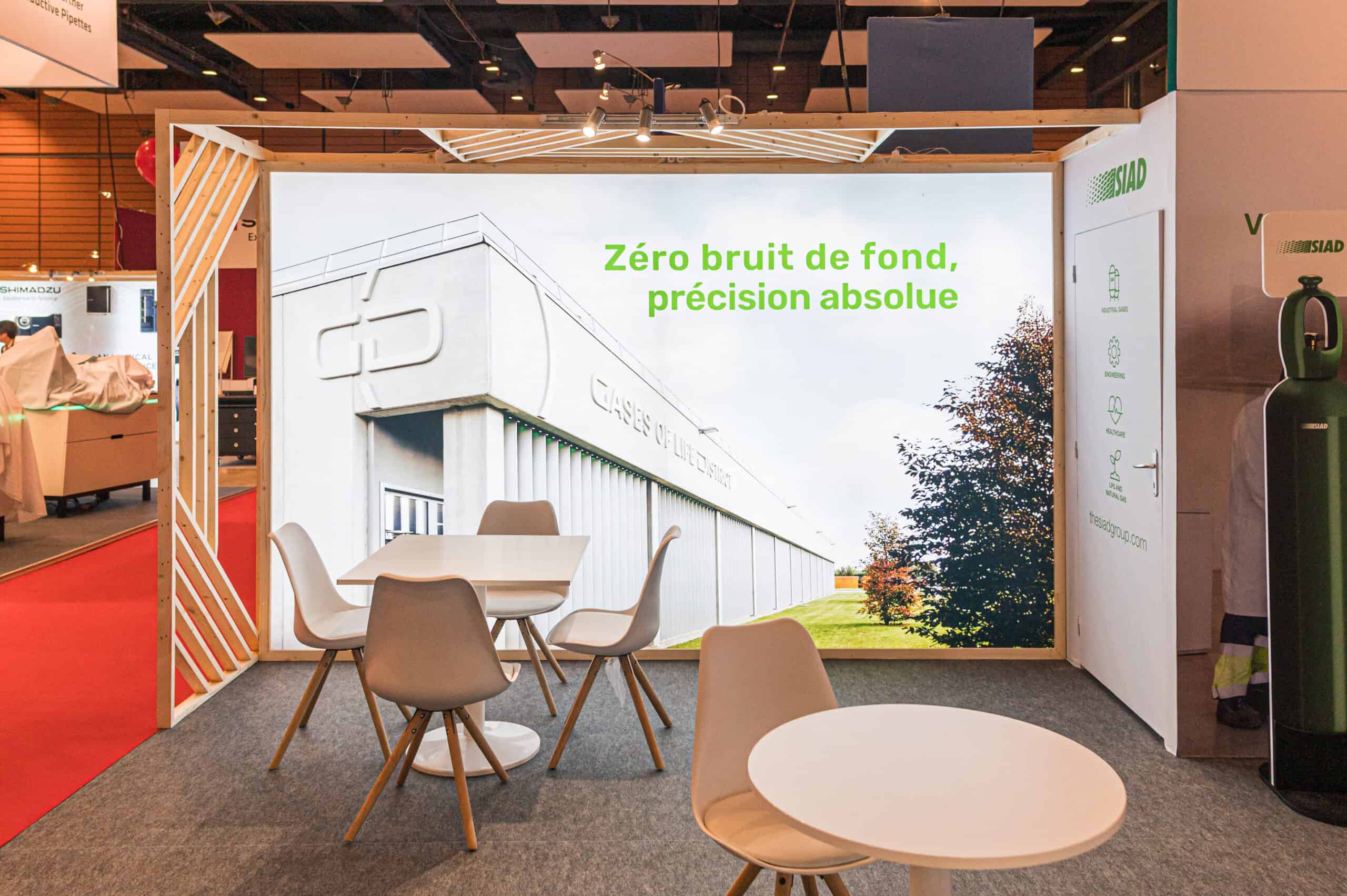Stand d'exposition avec mobilier moderne et grand écran pour événementiel.