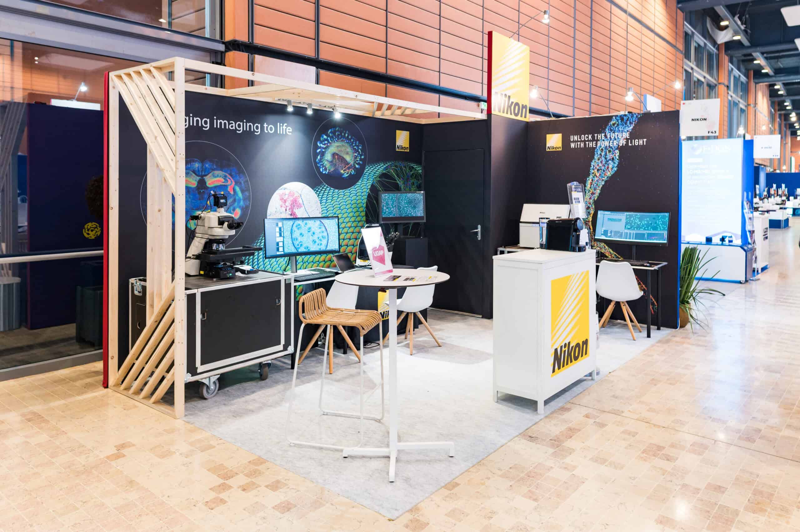 Stand d'exposition Nikon avec mobilier et équipements techniques pour événementiel.
