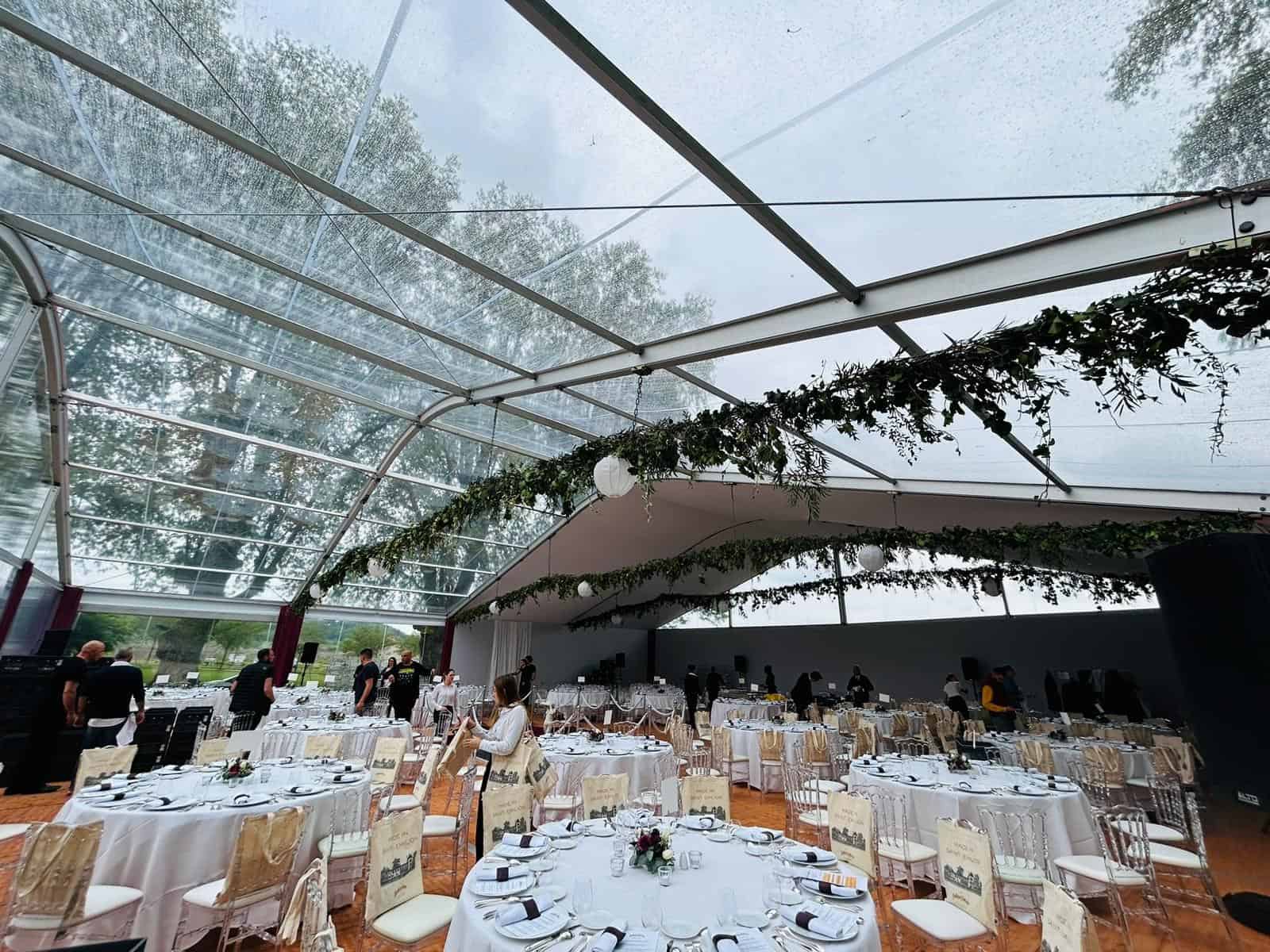 Indoor event space with elegant tables and a glass ceiling at Bellefont Belcier Castle.