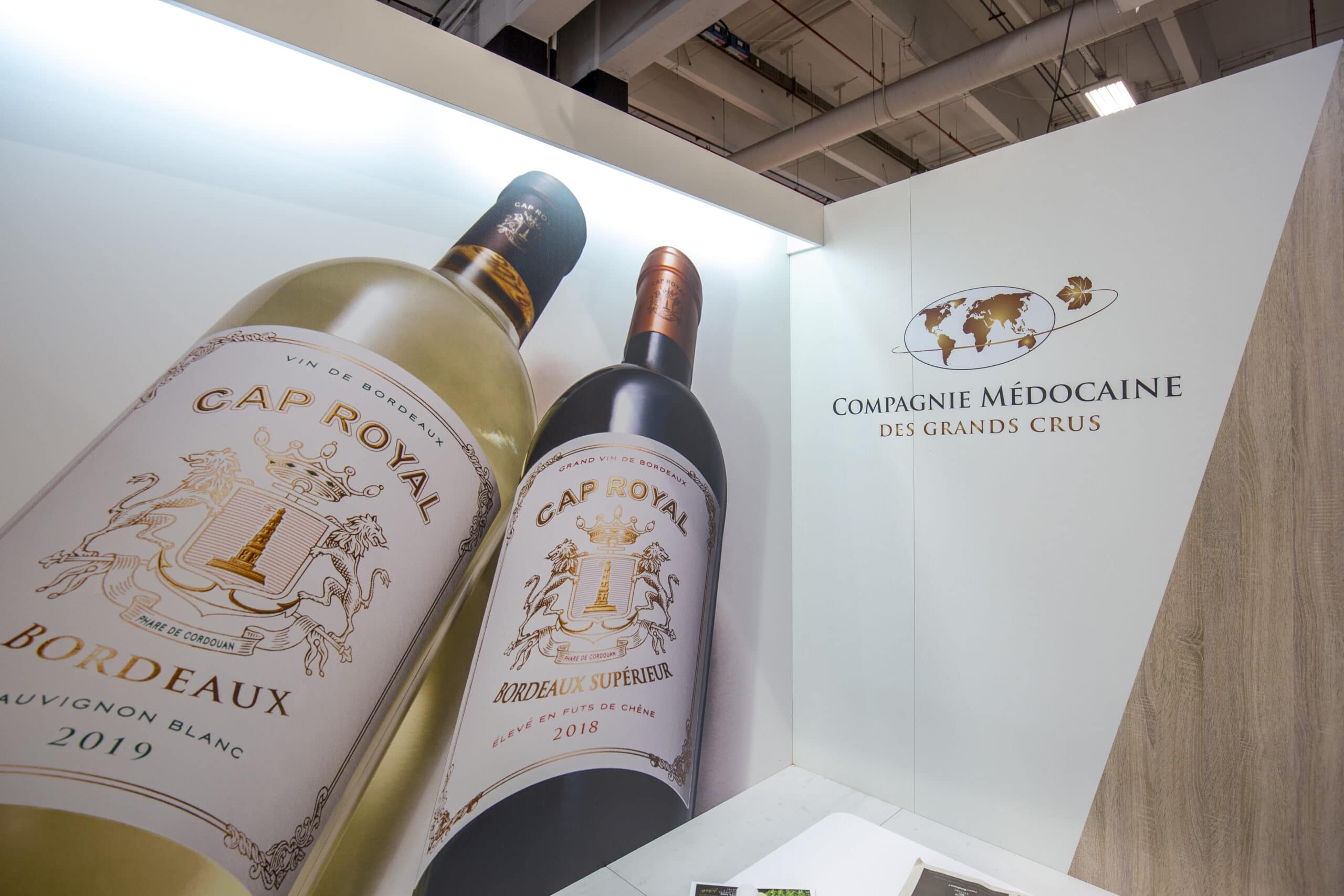 Stand d'exposition avec vins et logo Compagnie Médocaine lors d'un événement.