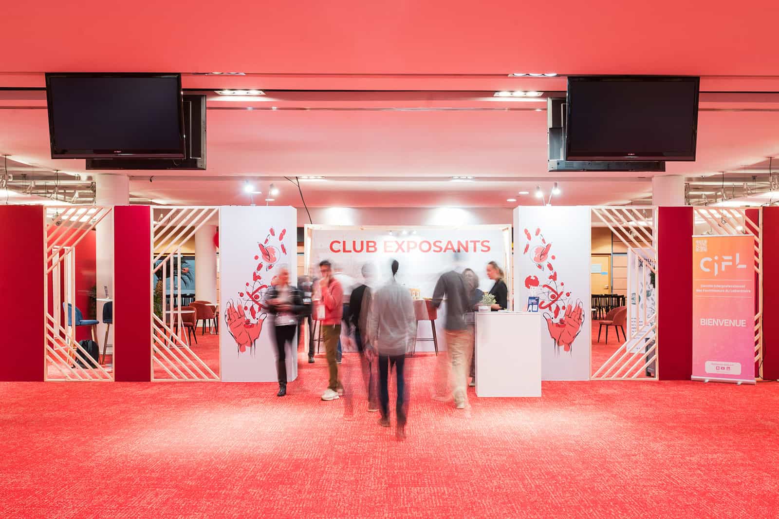 Co-Nect event at a conference with a red-themed exhibition area and attendees.