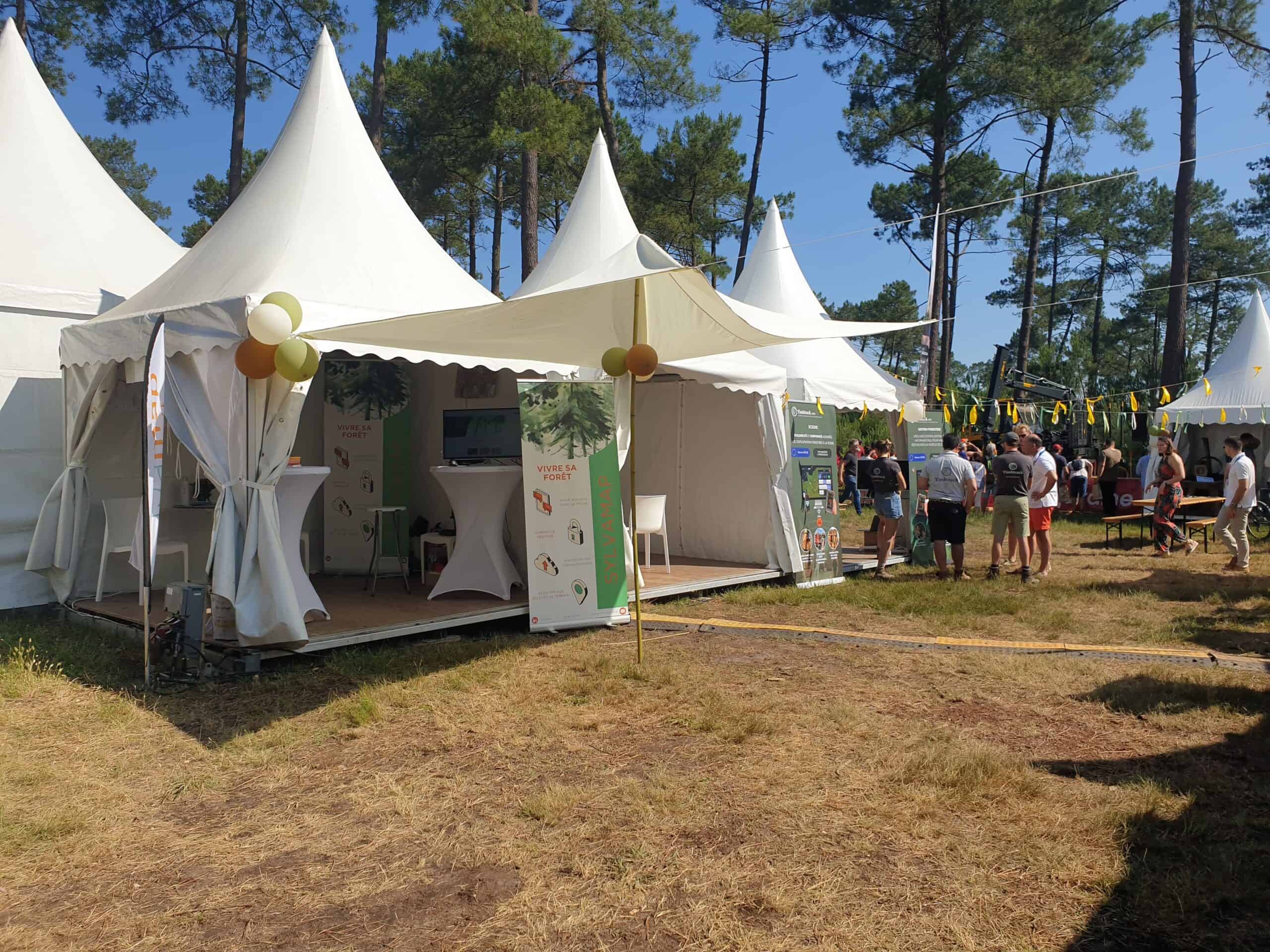 Outdoor event with white tents and visitors at FOREXPO exhibition.