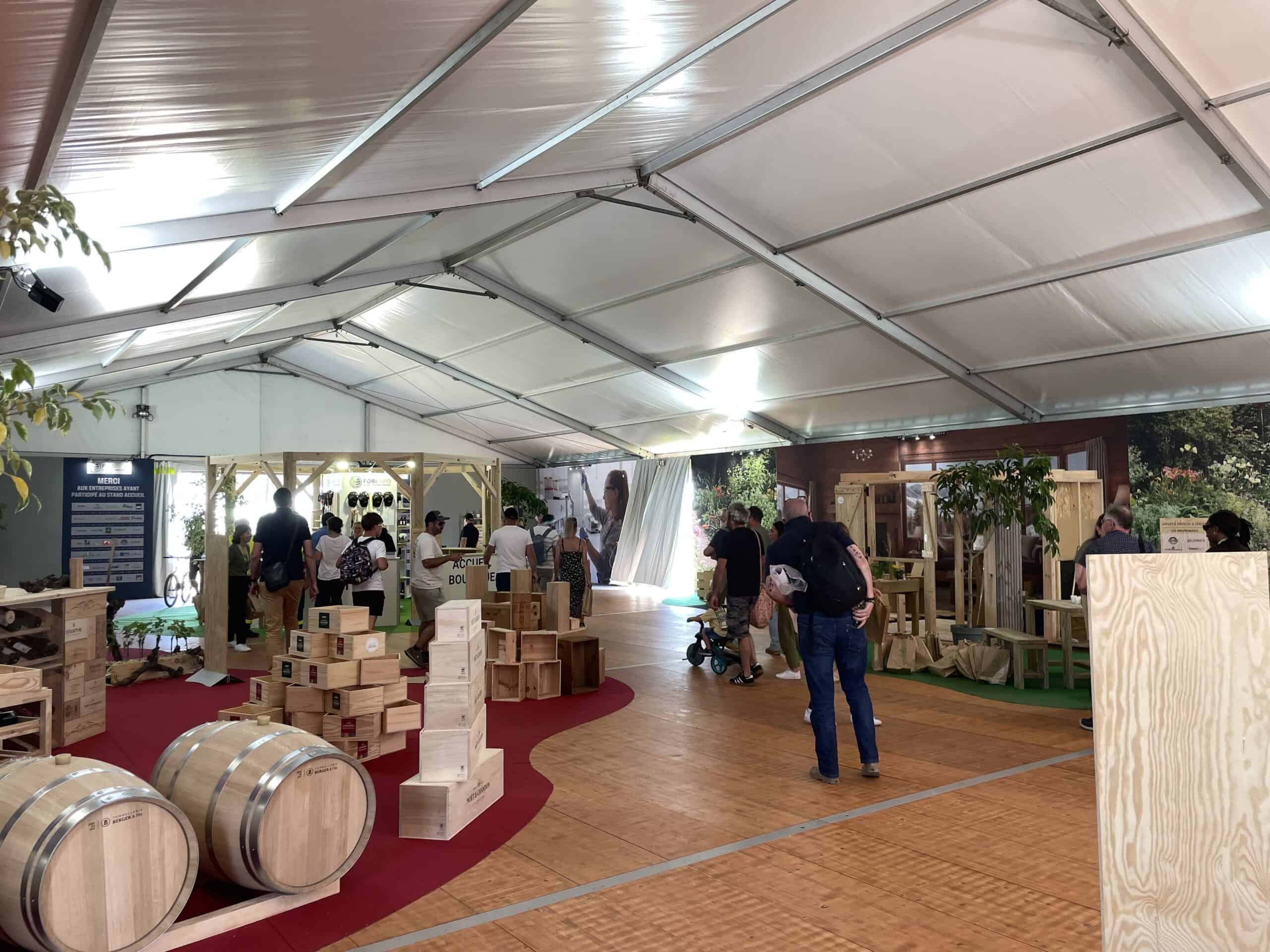 Trade show booth with wooden products and visitors at FOREXPO event.