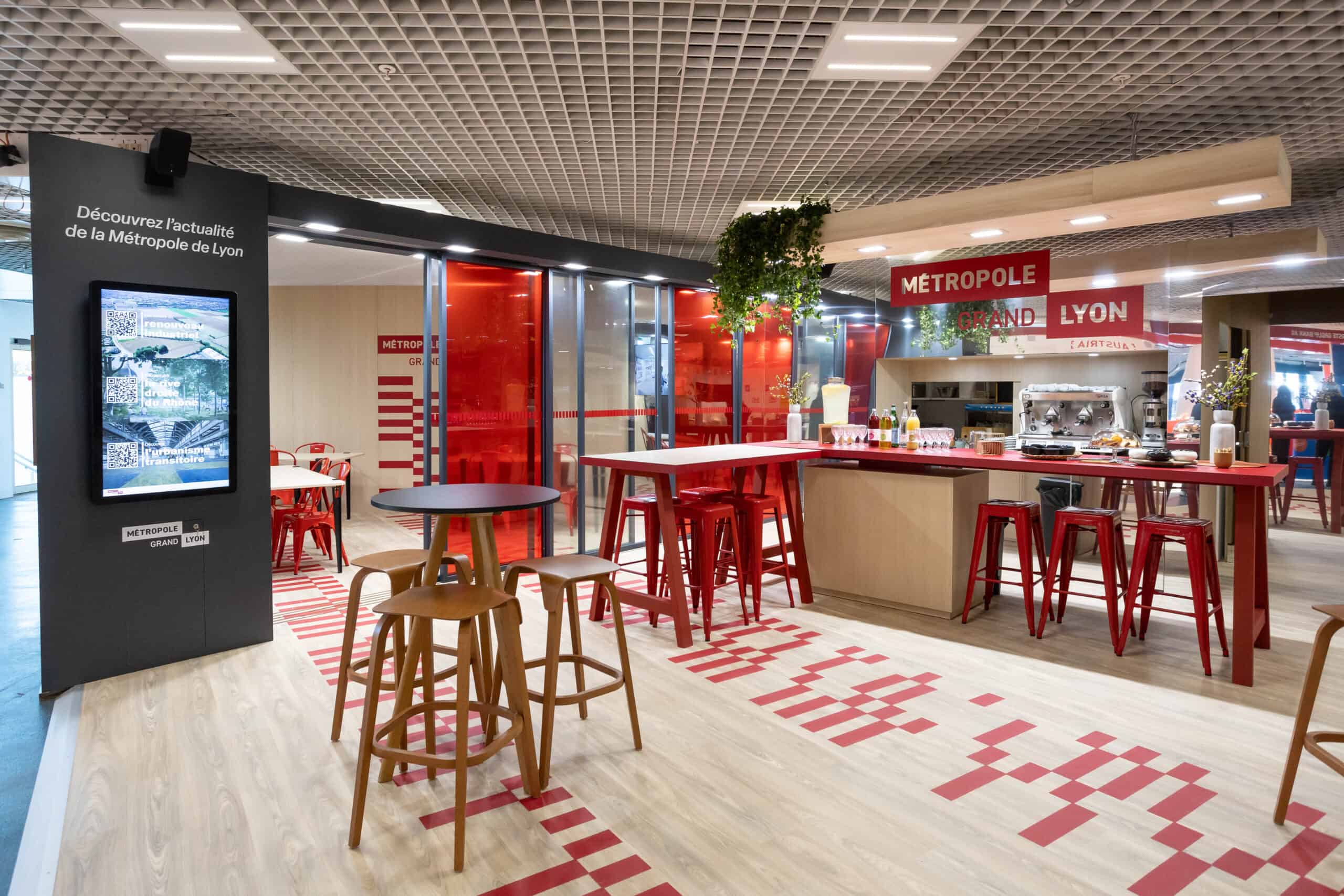 Modern visitor center with red accents and seating in Lyon, France.