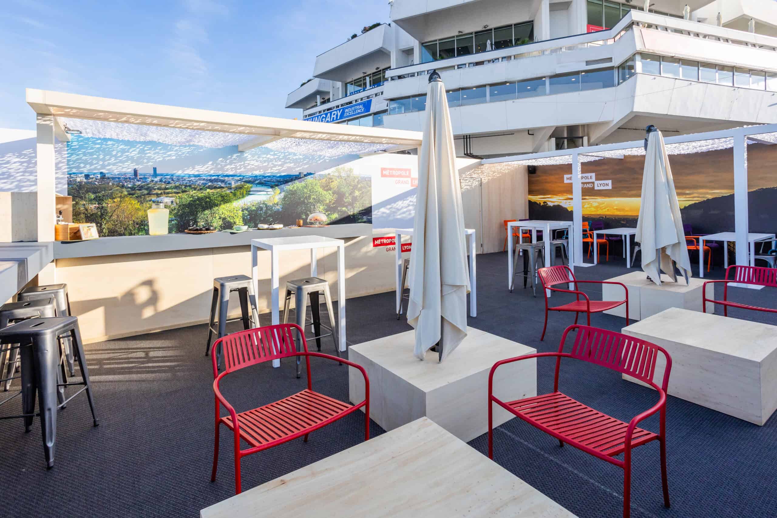 Outdoor rooftop terrace with seating and umbrellas in Greater Lyon.