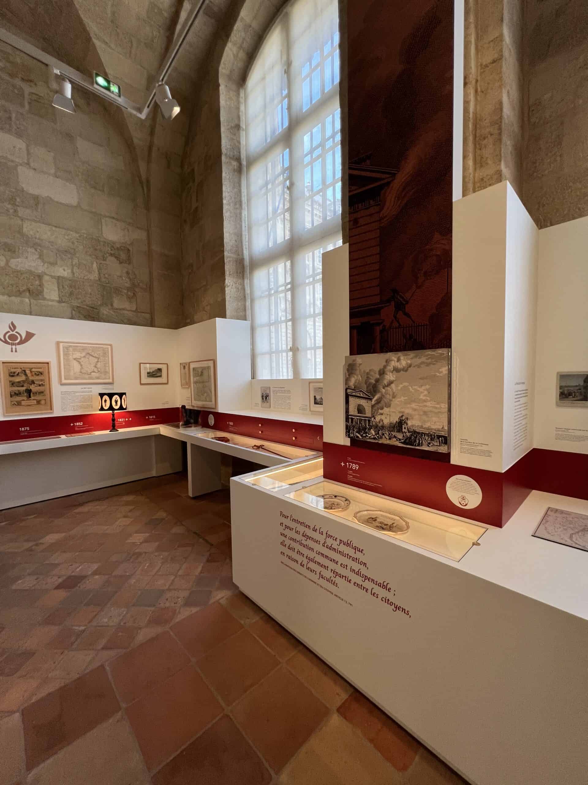 Installation d'exposition avec stands et mobilier dans un musée historique.