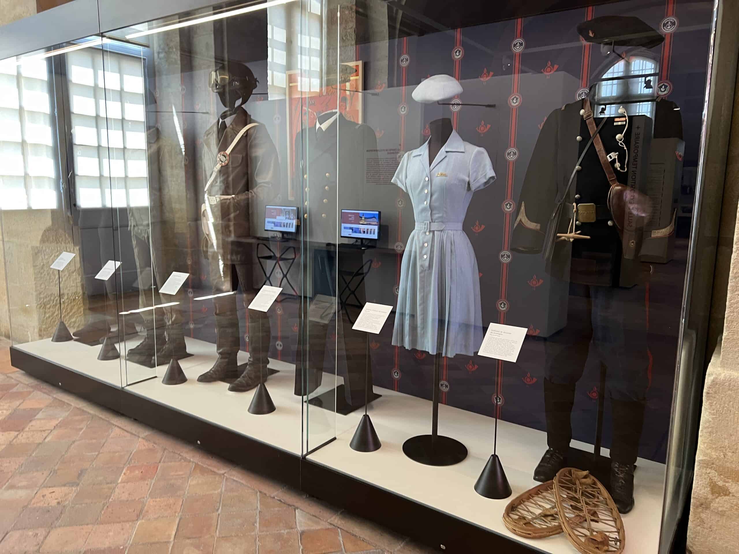 Vitrine d'exposition avec mannequins en uniformes et accessoires.