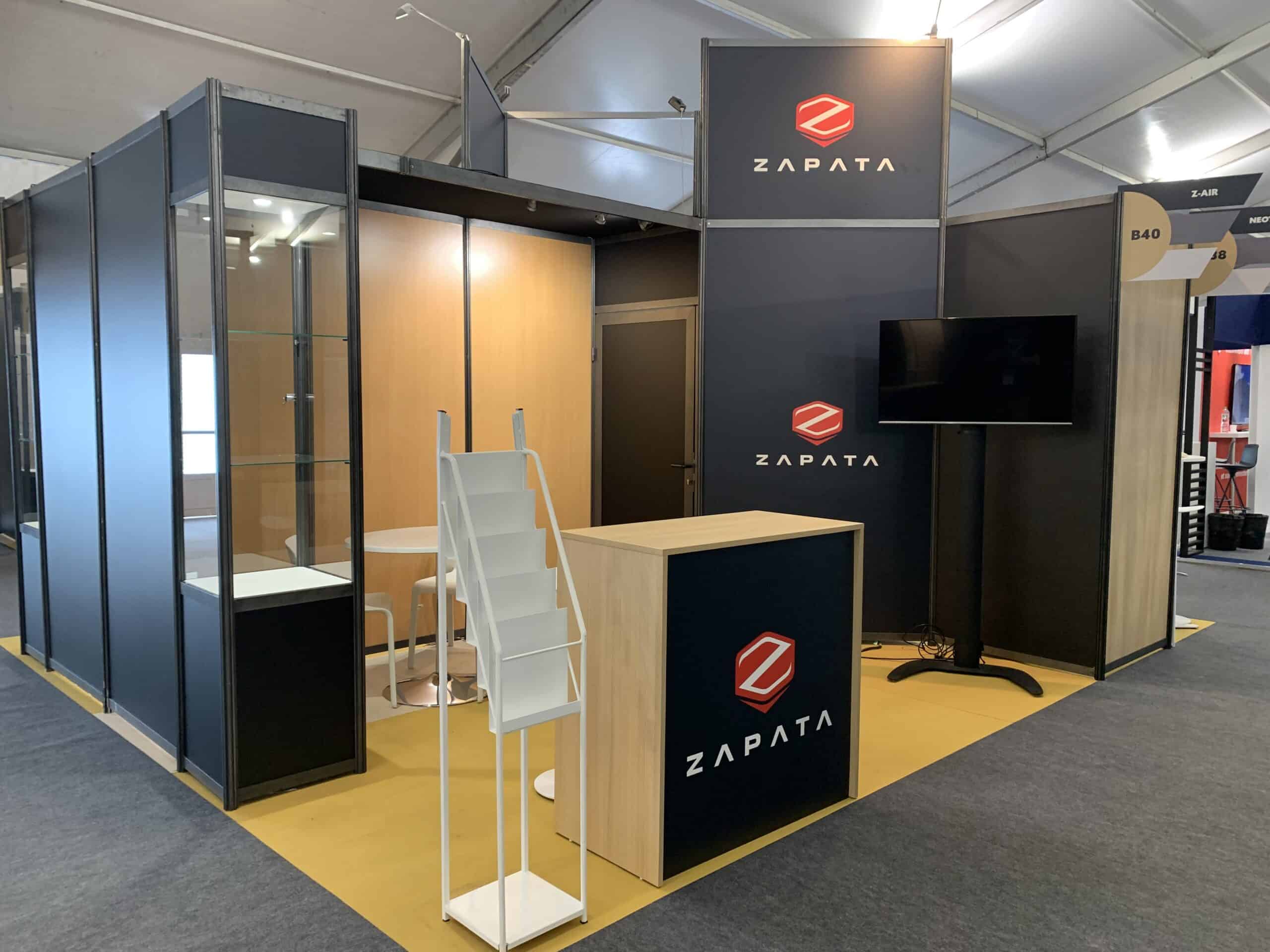 Zapata booth with furniture and a screen for a trade show.