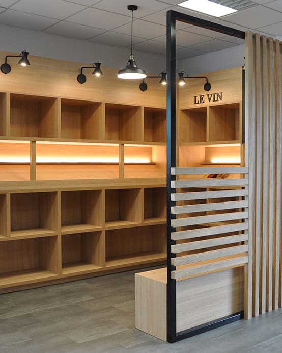 Espace de dégustation de vin avec étagères en bois et éclairage moderne.