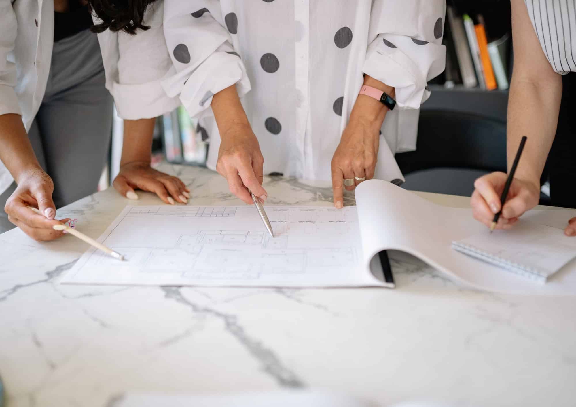Team of professionals collaborating on architectural plans at a meeting.