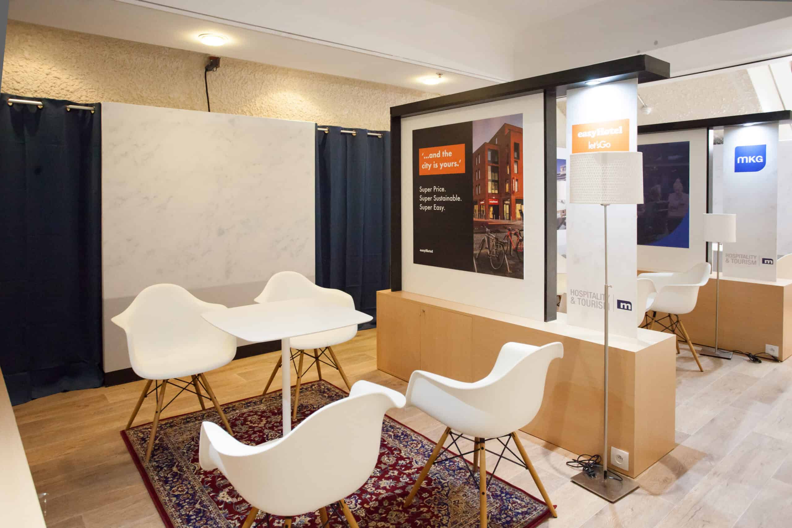 Espace d'exposition avec mobilier moderne et stands pour événementiel.