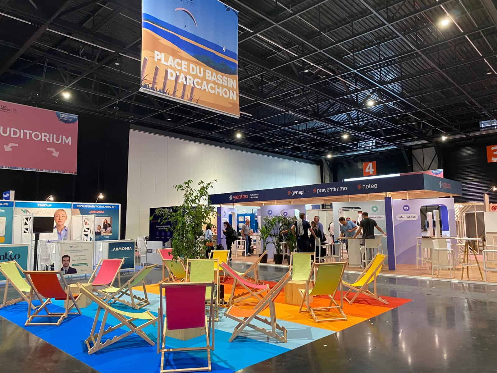 Co-Nect exhibition booth at a trade show with seating area and informational displays.