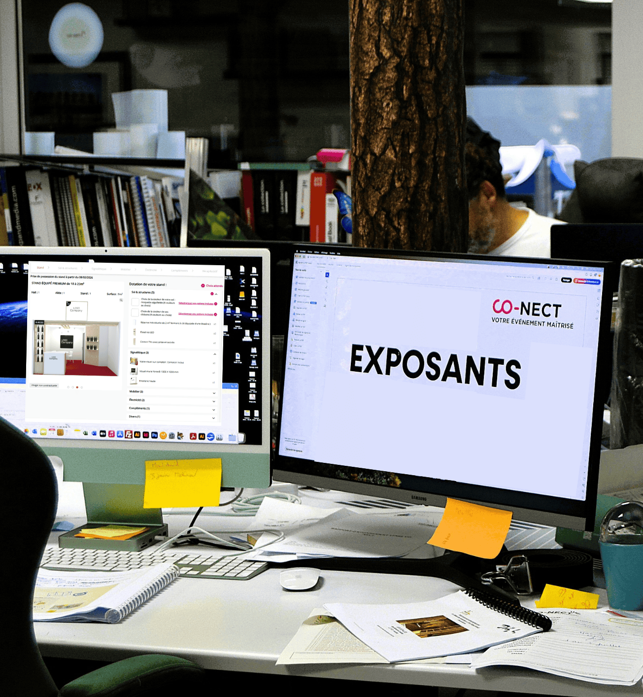 Office workspace with dual monitors displaying Co-Nect event information.