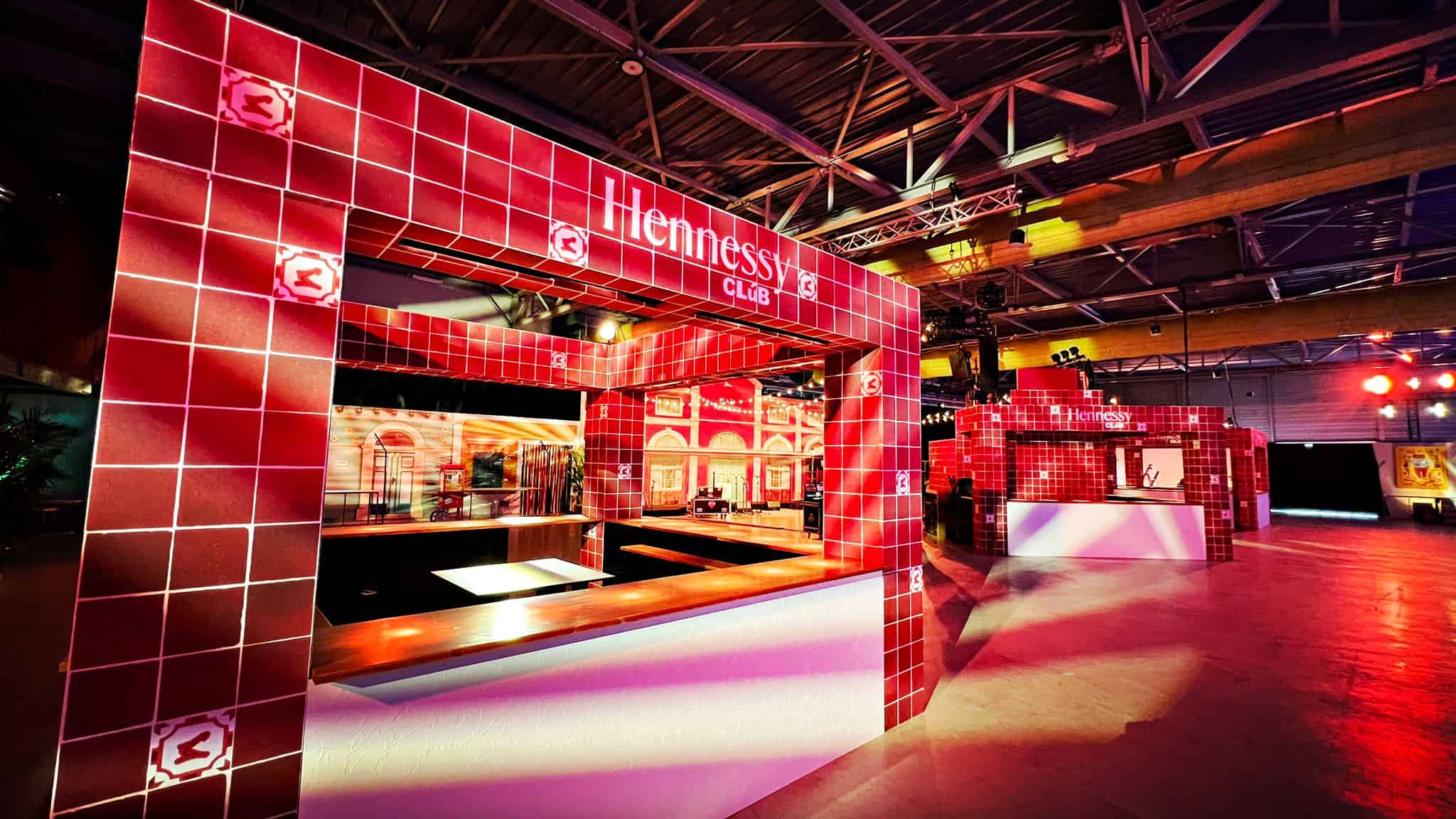 Hennessy Club booth at the convention with red tiled decor and lighting.