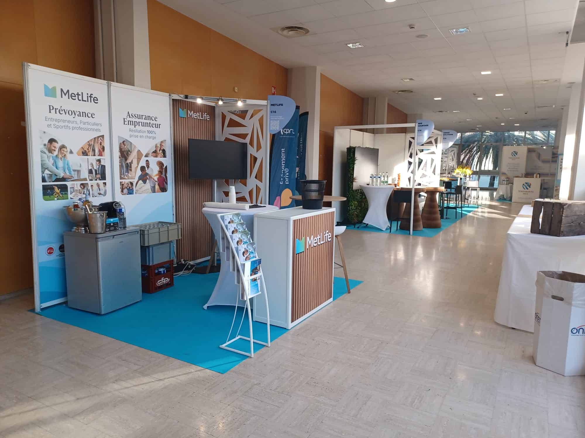 Co-Nect booth at brokerage event with MetLife branding and informational displays.