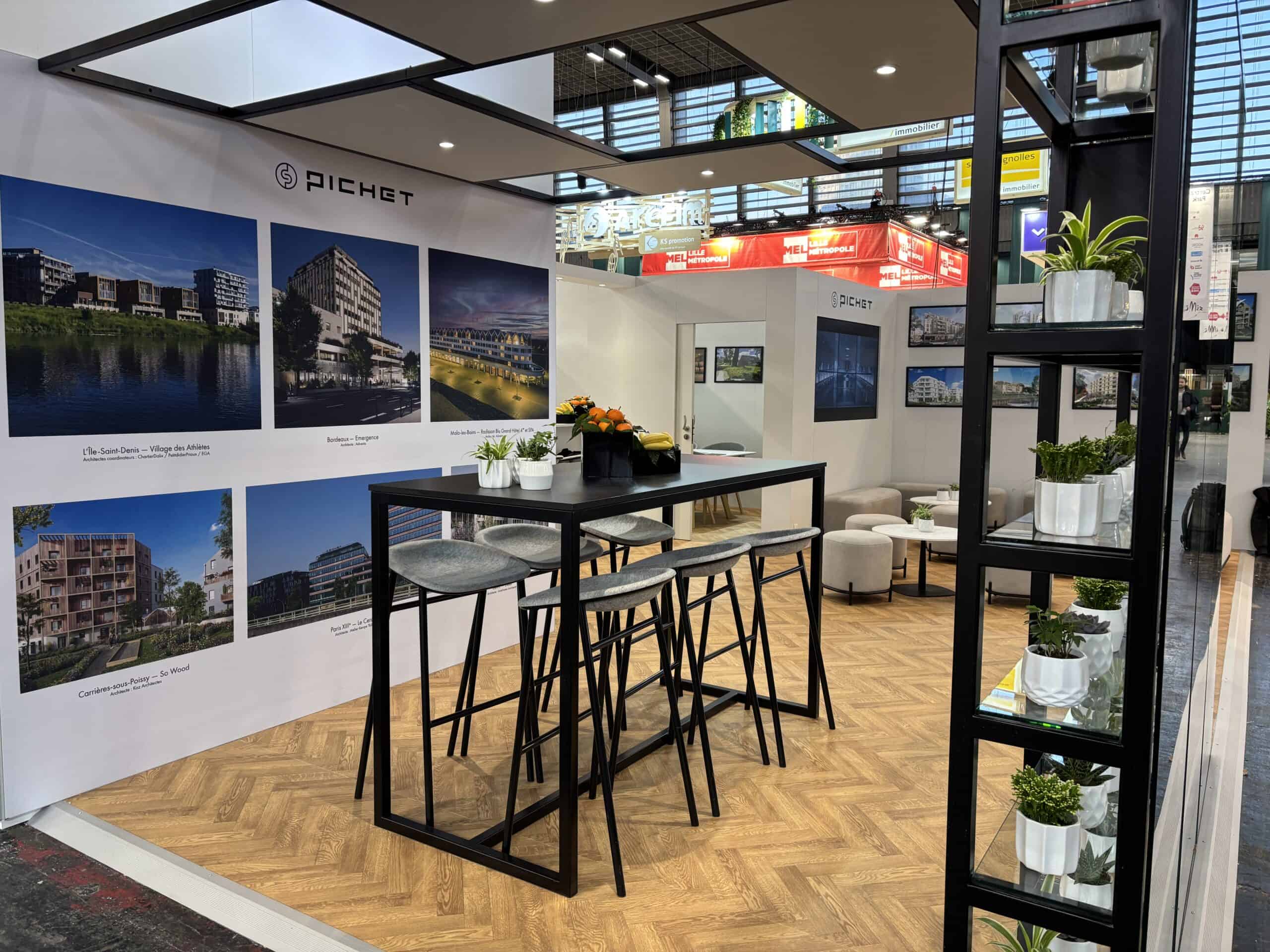 Modern exhibition booth for Co-Nect with architectural photos and seating area.