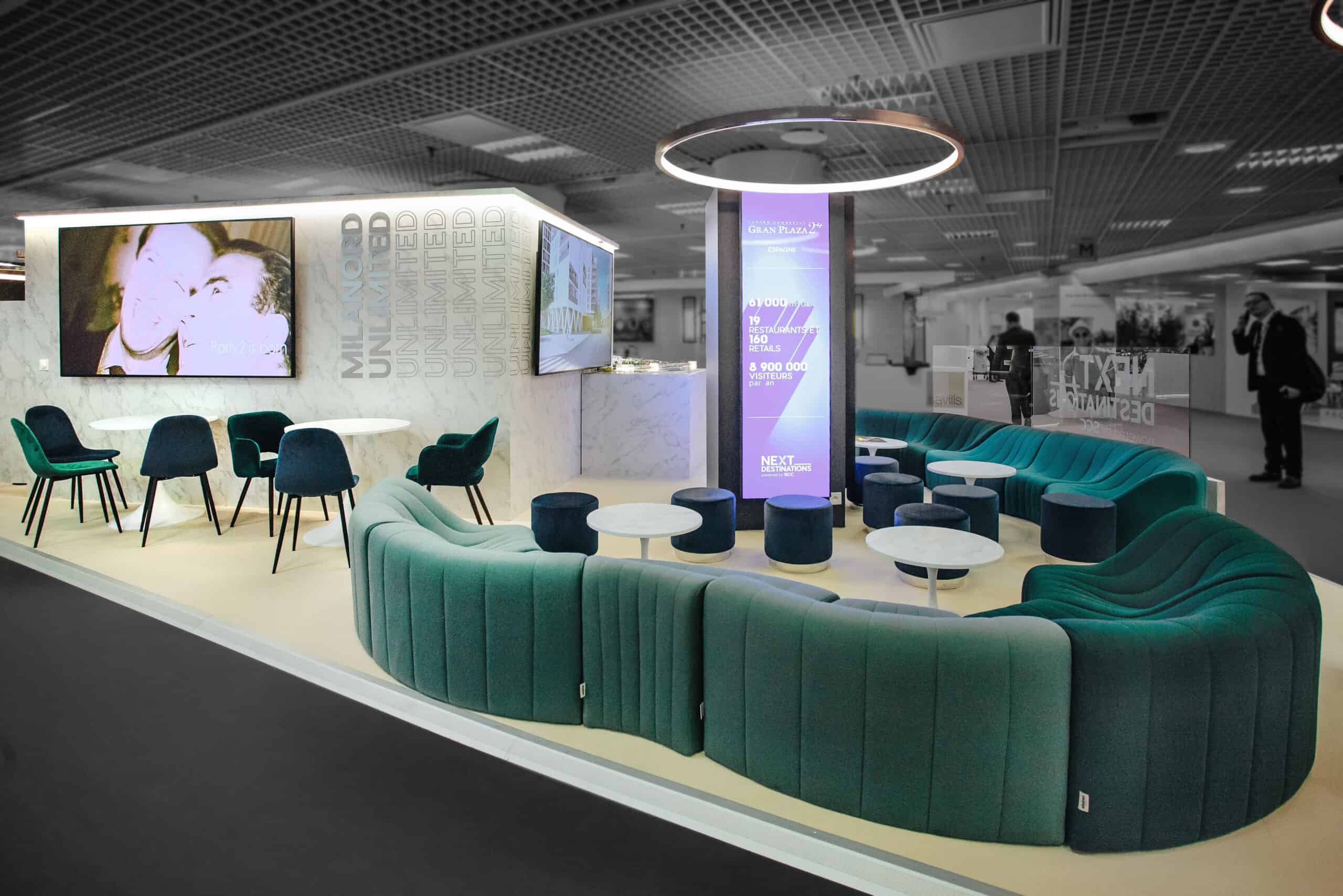 Modern Co-Nect exhibition booth with seating and digital displays at SCC.