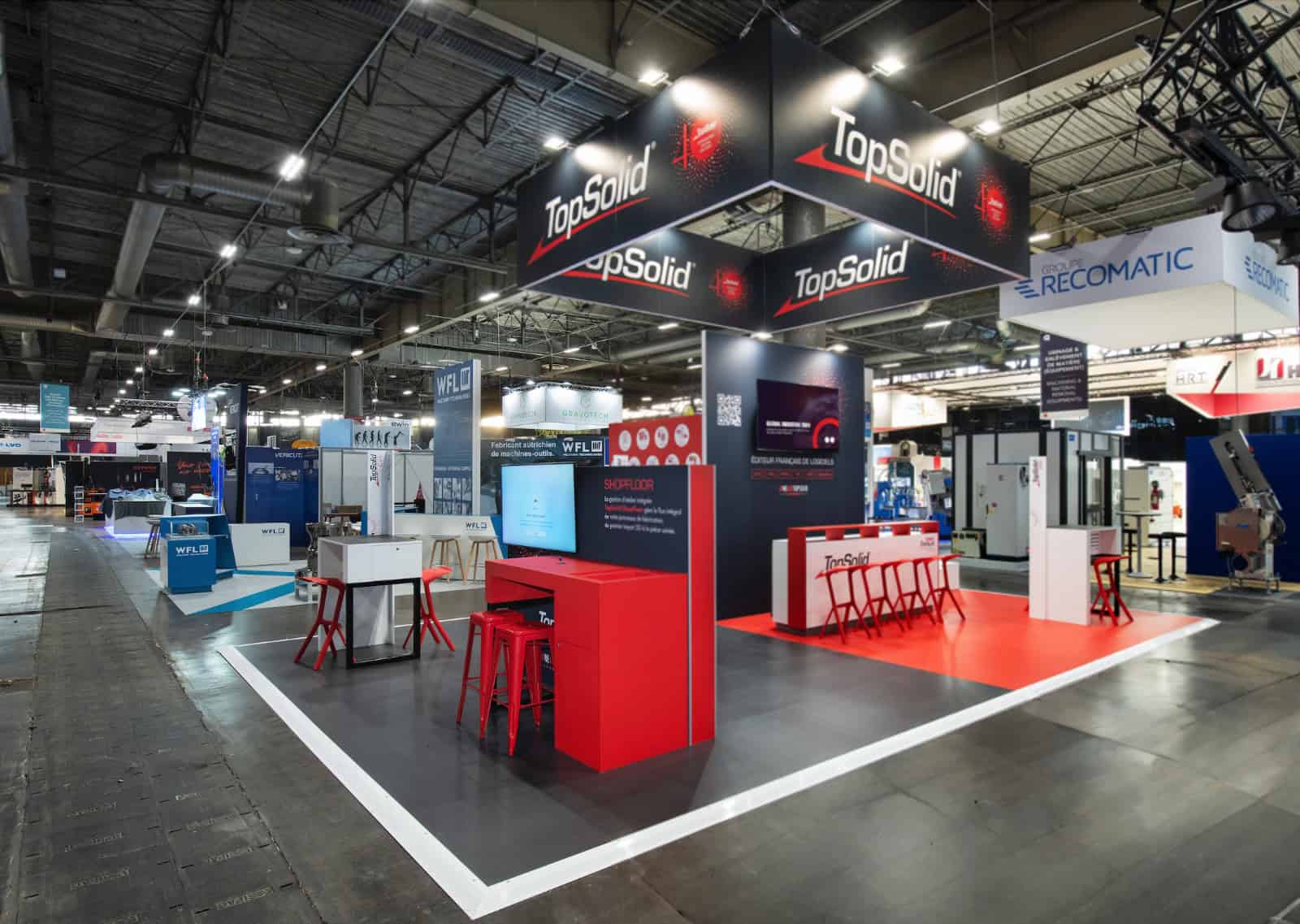 TopSolid booth at industry trade show with branding and product displays.