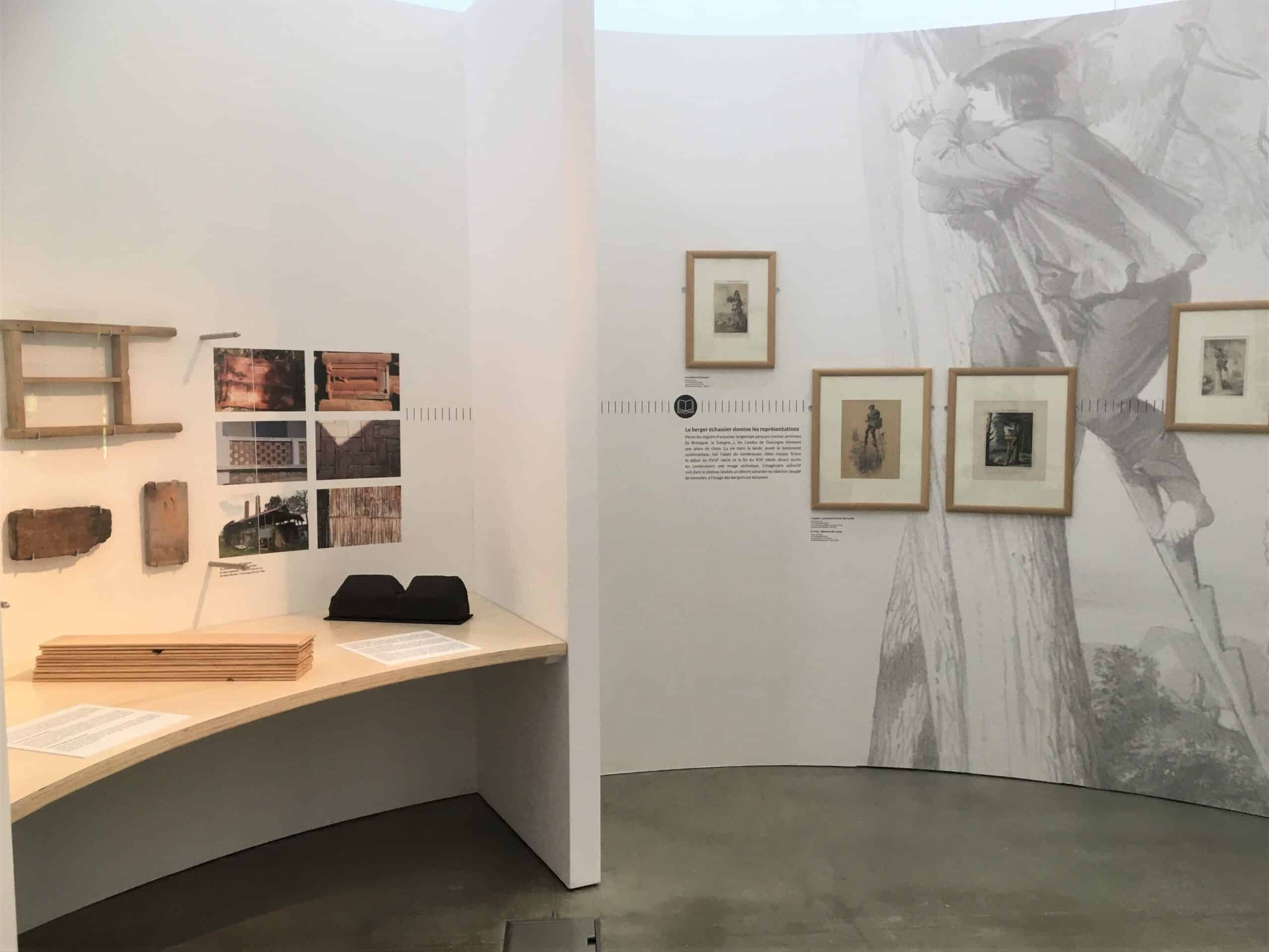 Installation d'exposition avec mobilier et œuvres d'art.